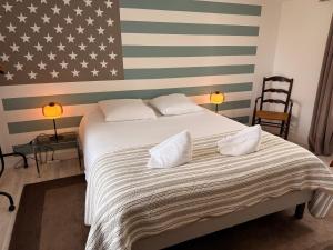 1 dormitorio con 1 cama grande con banderas americanas en la pared en Clos des Huards au milieu de la loire à vélo, en Cour-Cheverny