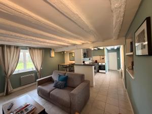 Una sala de estar con un sofá y una cocina. en Clos des Huards au milieu de la loire à vélo, en Cour-Cheverny