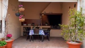 a patio with a table and chairs and plants at Casa Cruces in Sant Jaume d'Enveja