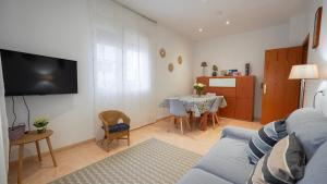 a living room with a blue couch and a table at Casa Cruces in Sant Jaume d'Enveja