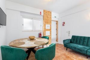 a living room with a table and green chairs at Cabanas de Tavira - T1 in Cabanas de Tavira
