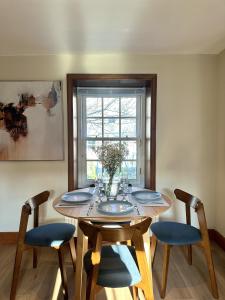 a dining room table with four chairs and a window at Barossa Nook, 2 Bedroom House in Perth
