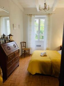 a bedroom with a bed and a dresser and a window at Grande Maison de village ZONZA in Zonza