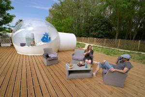 a man and a woman sitting in chairs in front of a bubble at Bulle SPA Paysanne in Jarcieu
