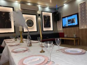 Una mesa con platos y vasos y una pluma sobre ella. en פאטה מורגנה רויאל - מתחם פרטי עם בריכה פרטית, en Beer Sheva