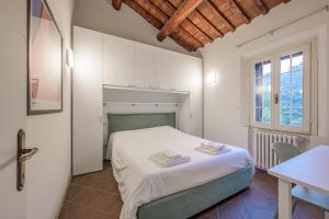 ein Schlafzimmer mit einem Bett und einem Tisch und einem Fenster in der Unterkunft Piazza Ariostea Apartment in Ferrara