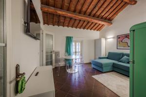 ein Wohnzimmer mit einem blauen Sofa und einem Tisch in der Unterkunft Piazza Ariostea Apartment in Ferrara