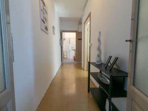 a hallway with white walls and a black cabinet at Welcomely - Casa Margherita in Varenna