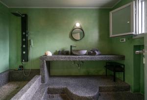 a green bathroom with a sink and a mirror at Villa in Kamares, Sifnos in Kamares