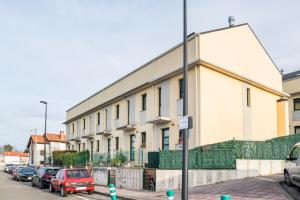 a large building with cars parked in a parking lot at Suite independiente con baño y terraza in Cartes