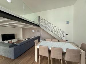 a living room with a table and a couch and a staircase at Apt. Virgo - Oasi di Menaggio in Menaggio