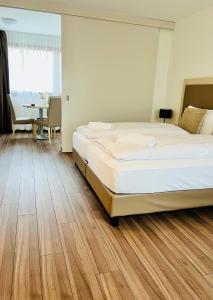 a hotel room with a bed and a dining table at Hôtel Domaine de la Sauge in Cudrefin