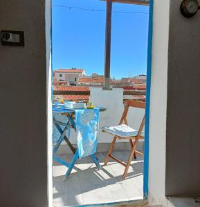 een tafel en stoelen op een balkon met uitzicht bij Nura's - Il Balcone sui Tetti in Alghero