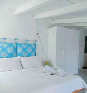 een slaapkamer met een wit bed met een blauw hoofdeinde bij Nura's - Il Balcone sui Tetti in Alghero