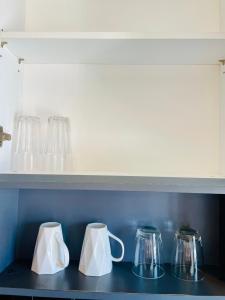 a row of glass jars and pitchers on a shelf at The base Condo luxury room by Numam in Pattaya Central +48 photos