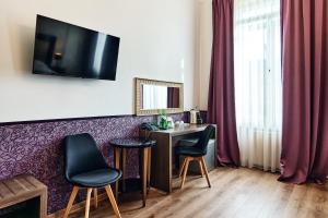 a room with a table and two chairs and a desk at Hotel Pension Baron am Schottentor in Vienna