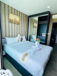 a hotel room with two beds with flowers on them at The base Condo luxury room by Numam in Pattaya +48 photos