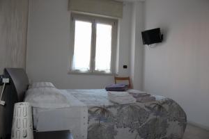 a bedroom with a bed and a window and a television at Staurenghi34apartmenT in Varese