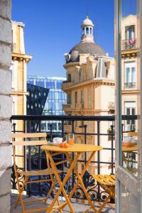 a table on a balcony with a view of a building at Hotel Khla Nice in Nice