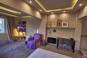 a living room with a purple chair and a tv at Lycabettus View Kaniggos in Athens