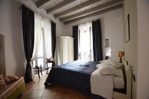 a bedroom with a bed in a room with windows at La Torre Bergamo House in Bergamo