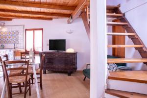 een woonkamer met een tafel en een televisie bij La Cambusa Apartment in Alghero