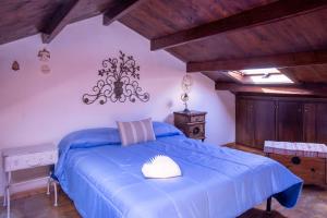 een slaapkamer met een blauw bed in een kamer met houten plafonds bij La Cambusa Apartment in Alghero