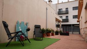 a patio with a green rug next to a building at Casa Cruces in Sant Jaume d'Enveja
