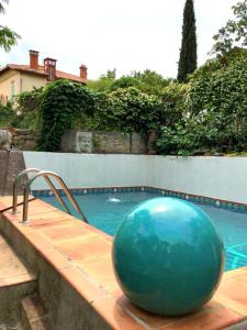 ein großer blauer Ball neben einem Schwimmbecken in der Unterkunft Jardin d'Eden in La Ciotat