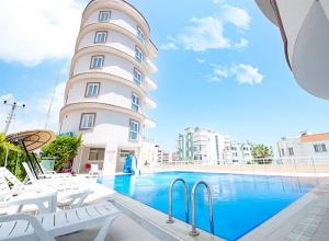 a building with a swimming pool next to a building at Truva REZİDANS in Merdivenlikuyu