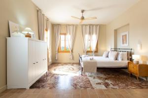 a bedroom with a bed and a dresser and windows at Villa Plaka 16 "The Bordeaux"-Drepano Nafplio in Drepana