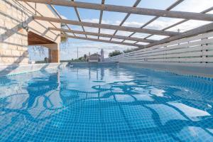 a large swimming pool with a wooden roof at Villa Marta Maria con giardino in Siracusa