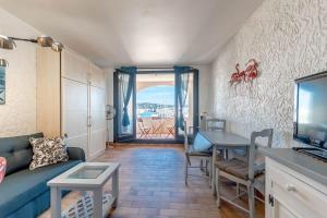 Una sala de estar con un sofá azul y una mesa. en La Marina l Views & Parking l Shellter Rentals, en Cogolin