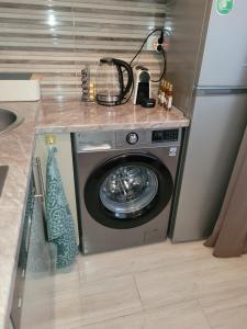 a washing machine in a kitchen with a counter at City Center Moku Apartman in Zenica