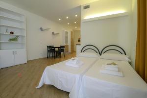 a bedroom with a white bed with two towels at La Cordata Accommodation - Martinelli 55 - Mono 7 in Rho +3 photos