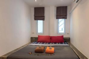 un letto in una camera con due cuscini rossi di Holy View 2br Shared Pool & Seaview - Chaweng a Chaweng Beach