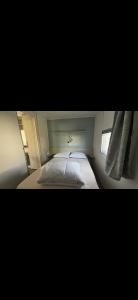 a small bedroom with a bed and a window at Mobilhome trigano au Camping Les Charmettes emplacement calme in Les Mathes
