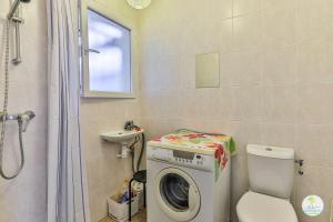 Biscarrosse bourg Duplex proche commerces 6 couchages في بيسكاروس: حمام مع غسالة ومرحاض