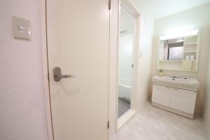 a white bathroom with a sink and a mirror at Miyazaki Mango Hotel - Vacation STAY 58309v in Miyazaki +21 photos