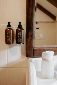two bottles of soap sitting on top of a bathroom sink at Forsthaus Wartenfels in Thalgau +21 photos