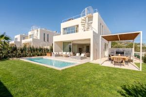a villa with a swimming pool and a yard at Modern Sea View Villa, Heated Pool,Rooftop Jacuzzi Outdoor Kitchen 12min faro Airport in Santa Bárbara de Nexe