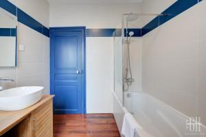 a bathroom with a blue door and a sink and a tub at Maison familiale bords de Loire avec jardin et 3 Chambres in Saint-Cyr-sur-Loire +35 photos