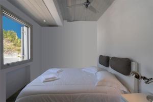 a white bedroom with a bed and a window at Villa in Kamares, Sifnos in Kamares +49 photos