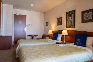 a hotel room with two beds with blue pillows at Boston Plaza Kusatsu Biwa Lake - Vacation STAY 15437v in Kusatsu