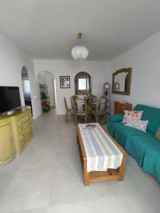Una sala de estar con un sofá verde y una mesa. en Apto Pueblo Luna, en Mojácar