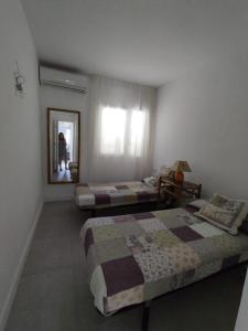 Un dormitorio con dos camas y un espejo y una ventana. en Apto Pueblo Luna, en Mojácar