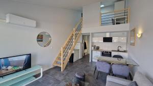 a living room with a staircase and a kitchen at Appartement T2 avec Balcon, Parking Privée à 2min de la plage, Rue Piétonne in Saint-Jean-de-Monts