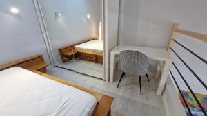 a small bedroom with a desk and a chair at Appartement T2 avec Balcon, Parking Privée à 2min de la plage, Rue Piétonne in Saint-Jean-de-Monts