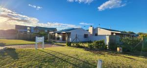 ein Haus mit einem Schild vor einem Hof in der Unterkunft The Beach Cottage Betty's Bay in Bettyʼs Bay