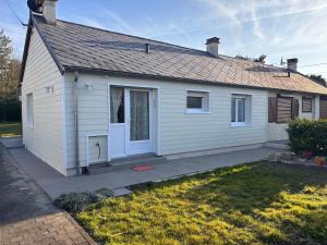 a white house with a door and a yard at La CaMaNi in Quend-Plage